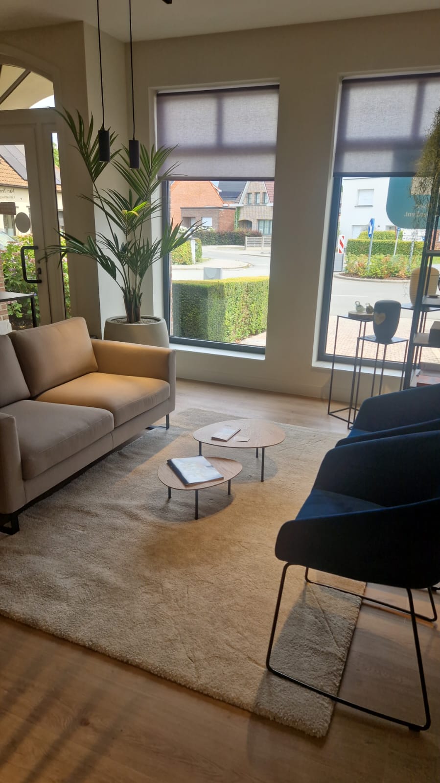 Winkelruimte met ruime zitbank en stoelen aan twee grote ramen. 